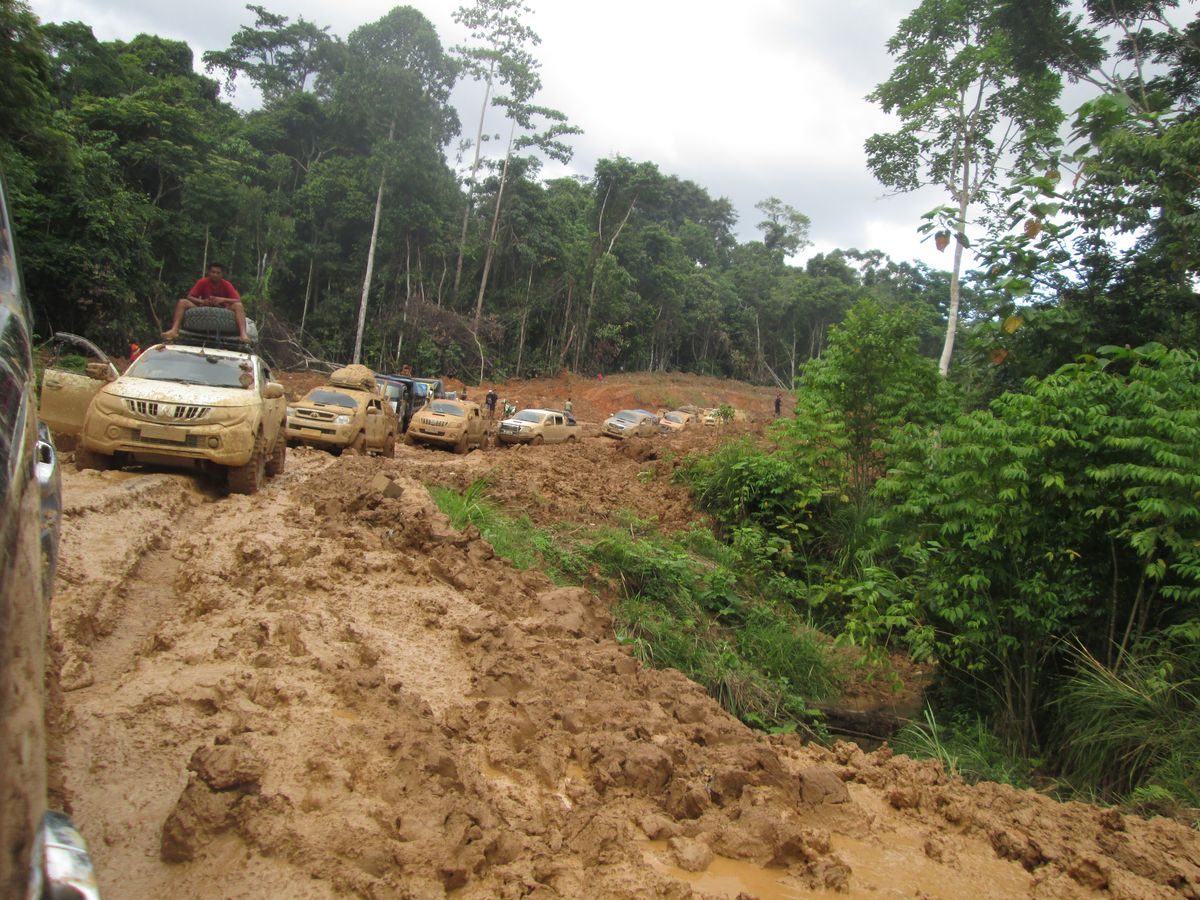 Konvoi kendaraan melintasi jalan tanah berlumpur di ruas Trans-Papua Manokwari-Teluk Bintuni