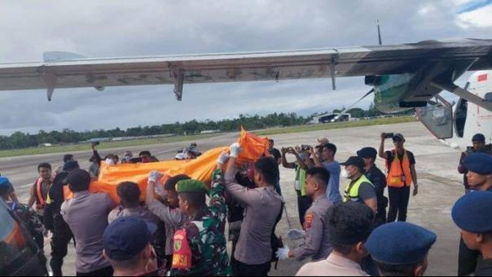 Petugas mengevakuasi kantong jenazah korban pembantaian warga sipil Nduga ke dalam pesawat di Timika, 16 Juli 2022