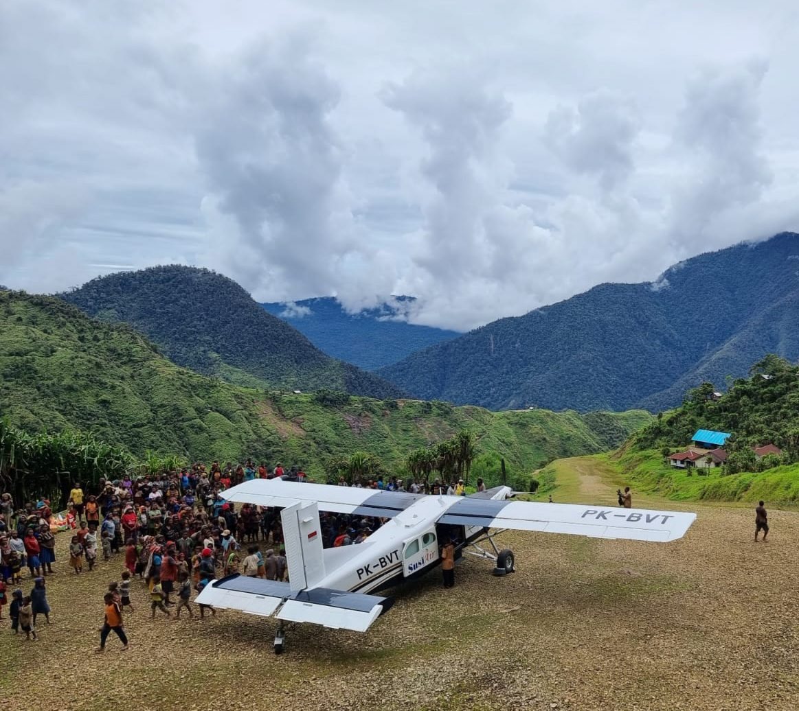 Pesawat perintis kecil terparkir di landasan tanah di kampung pegunungan Papua