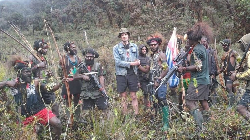 Phillip Mehrtens bersalaman dengan pria bersenjata sambil membawa bendera Bintang Kejora